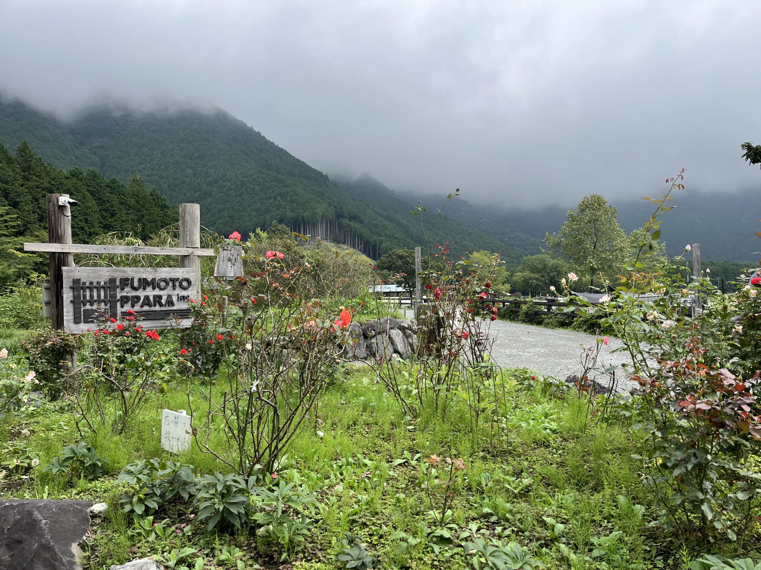 雲に覆われた山を背景にしたふもとっぱらの看板